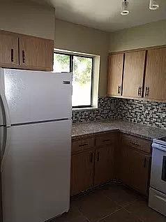 kitchen with all appliances; tiled backsplash; window facing front of property