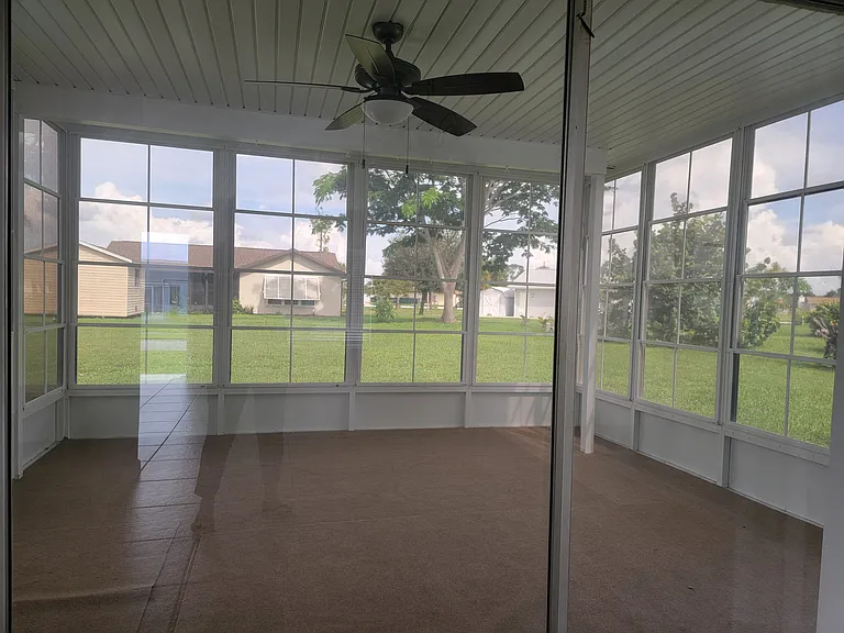 Screened lanai area has ceiling fan and windows on 3 sides