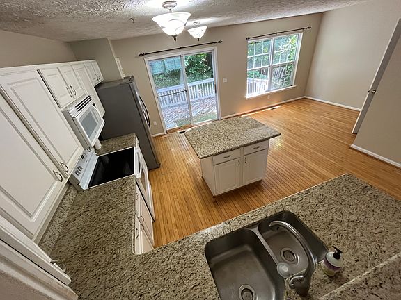 Bright eat-in kitchen with island, rear deck and half bath. High neck faucet with pullout spray