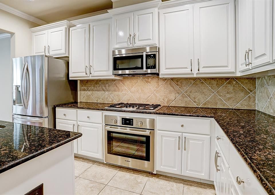 Beautiful white cabinets and stainless appliances show off this incredible kitchen!