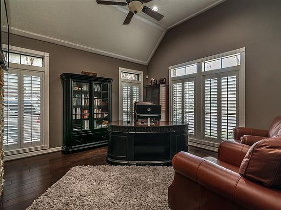 Vaulted study has wood flooring, Plantation shutters.