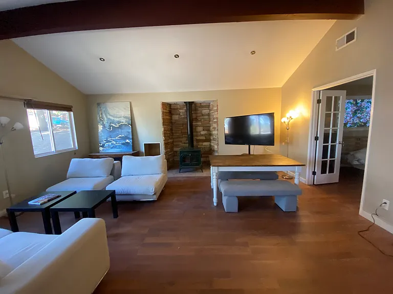 Living room with vaulted ceilings and wood burning stove/fireplace.