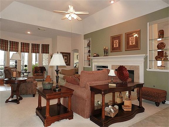High ceilings and a double-sided fireplace in this den/living room.