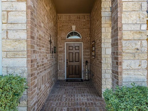 A brick covered front porch beckons your guests to enter the home!