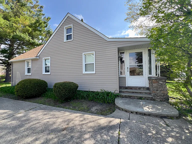 Driveway side of home with enclosed front porch