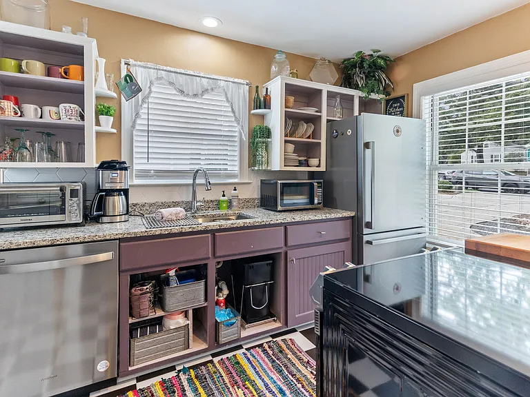 Kitchen at Hunsucker's was completely remodeled in 2023 and features stainless appliances and checkerboard tile floor all within walking distance of Downtown and Cone Hospital