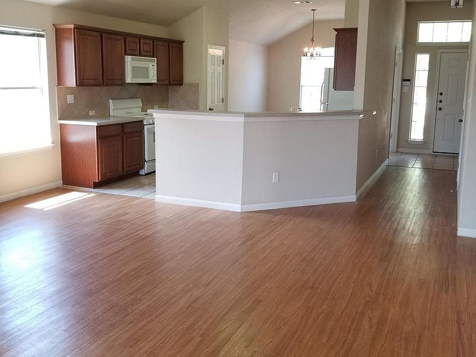 Living room and kitchen view. The door seen is the front entrance.