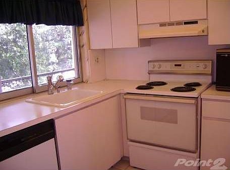 Kithchen with new appliances and new cabinets overlooking the screened in balcony