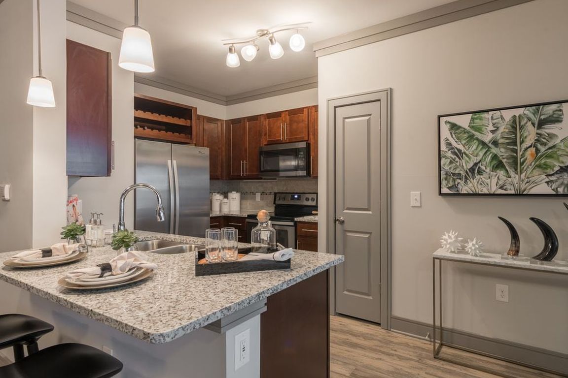 Modern Kitchens with oak shaker-style cabinetry, pendant lighting, granite countertops, and stainless steel appliances
