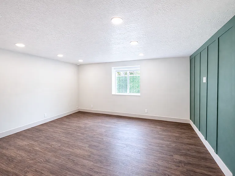 Bright and spacious living area with modern finishes and accent wall.