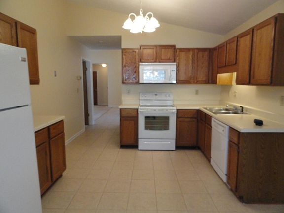 Kitchen with updated appliances and vaulted ceilings.