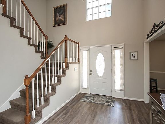 Wonderful lighting in the front foyer with a beautifully detailed grand staircase and gorgeous chandelier.