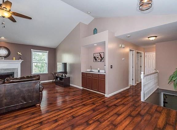 Vaulted Great Room with a better view of the wet bar.  Bedrooms are located down the hall.  The basement has spindled railing, and is partially finished, just waiting for your finishing touches.