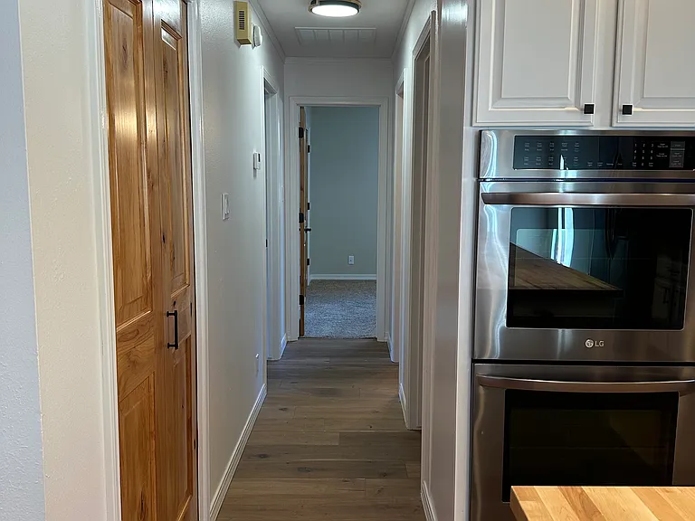 Hallway to 2 bdrms, bath, garage, stairway up