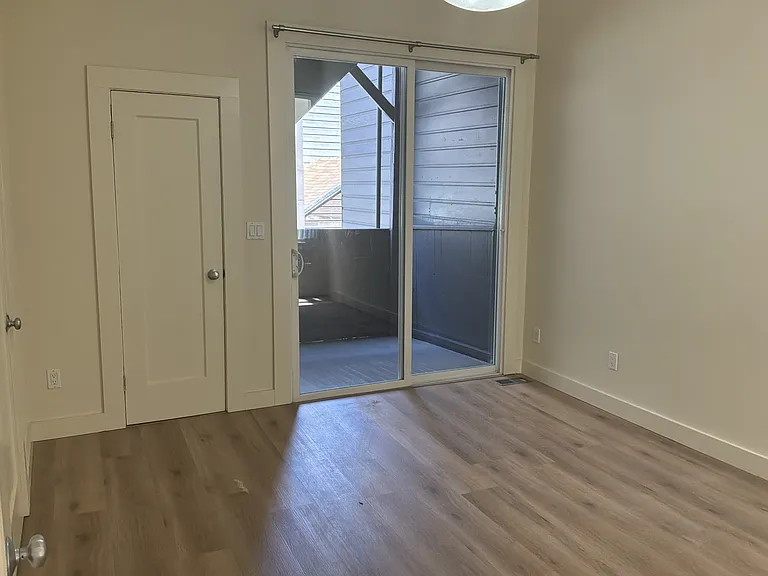 Second bedroom with closet, powder room, and deck access.