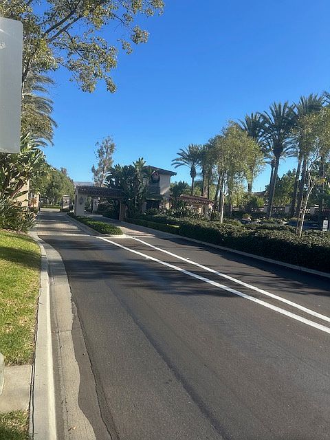Long grand palm tree lined driveways into and out of the gated community with a manned guardhouse.