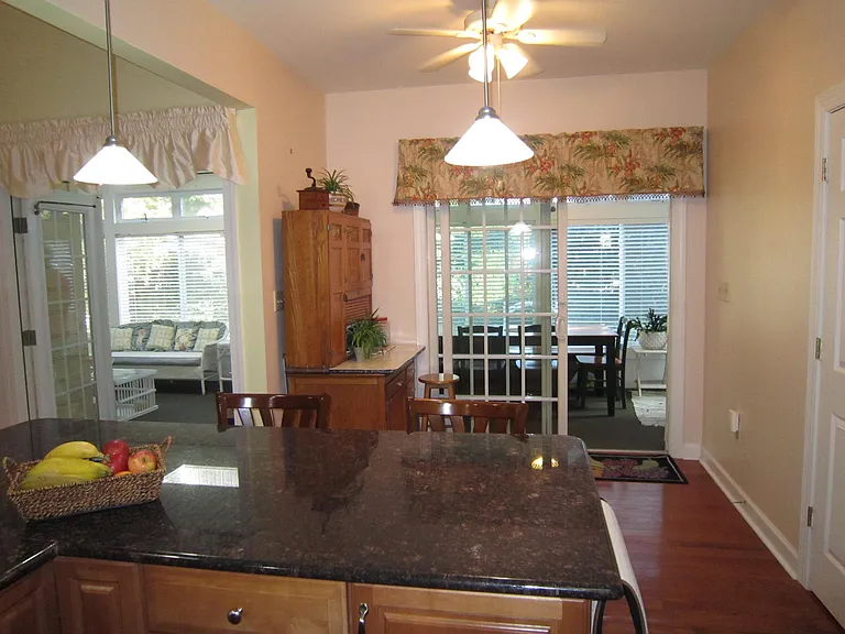 Kitchen with sitting area and glassed in Florida Room behind center island