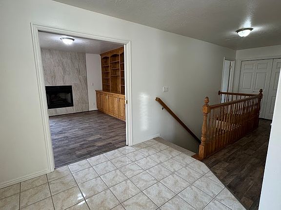 entry with view of stairway and dining room/fireplace looking through where pocket doors are open