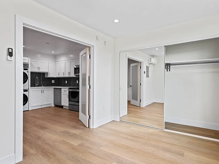 Bedroom with Double-Doors Leading to Open-Concept Kitchen