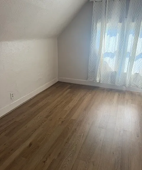 Upstairs front bedroon with wood flooring, closet and ac unit