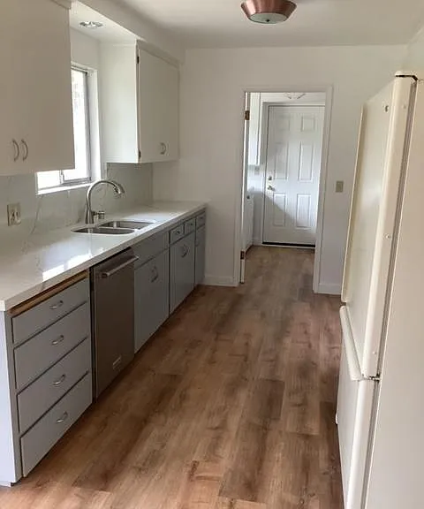 Kitchen with Quartzite countertops, dishwasher, refrigerator.