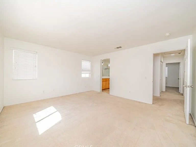 This picture shows the Master bedroom with a view of the hallway and entry to the Master bathroom. Please note: Home has been upgraded with new carpet that is not shown in this picture.