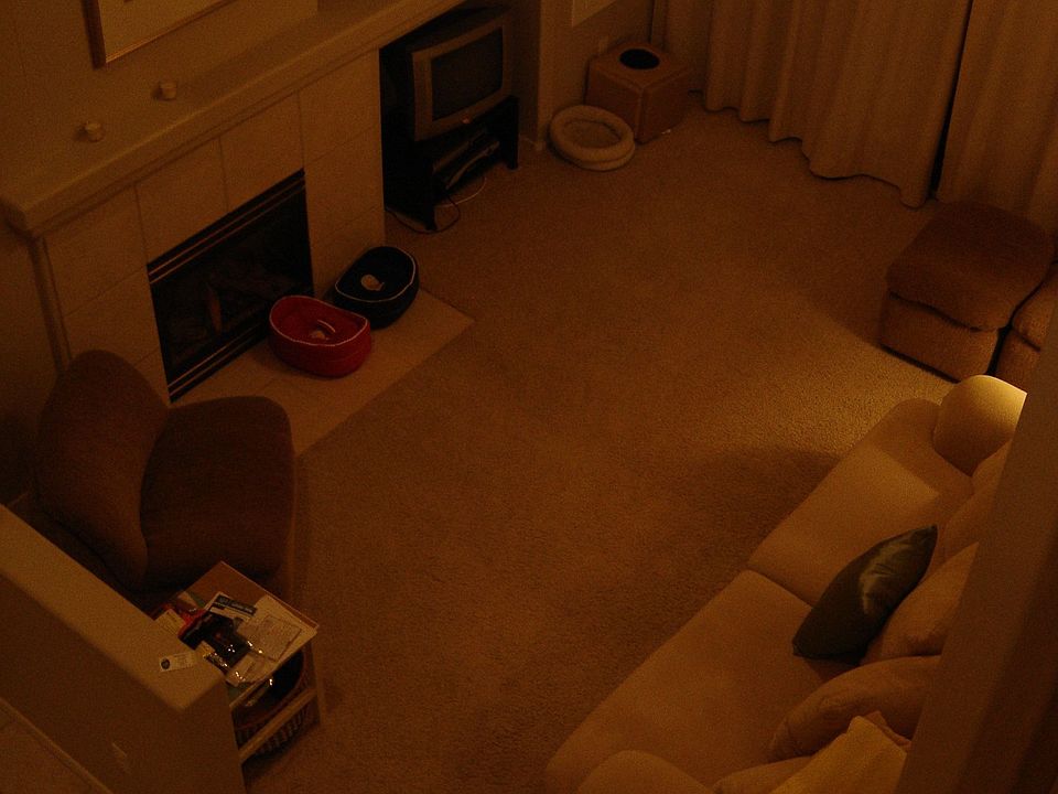 View of living room from loft, cozy gas fireplace, designer drapes