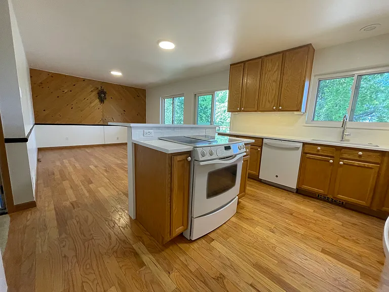 View from more formal dining room looking into kitchen - New quartz countertops, Jenn Air convection downdraft oven range self-cleaning. Bright new lighting - under cabinet ceiling. Refinished oak flooring, MasterCraft Oak cabinets