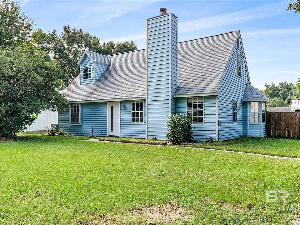 Back of house with a lawn
