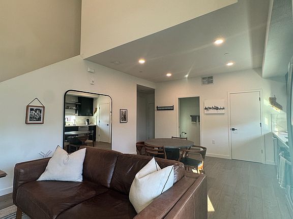 Living area, half bath along wall and staircase leading to bedroom