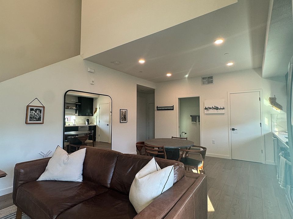 Living area, half bath along wall and staircase leading to bedroom