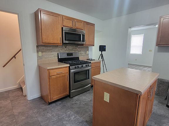 Kitchen has center island, stove, refrigerator & microwave.