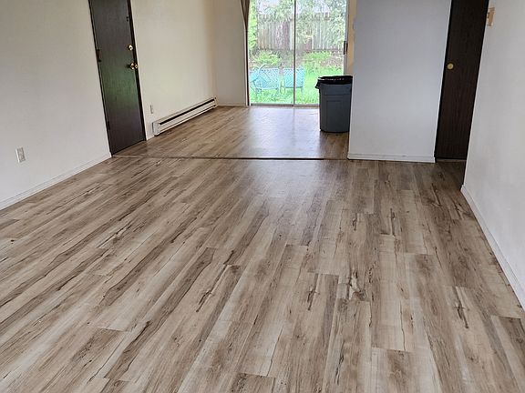 View from inside front door looking past living room to dining room to backyard slider