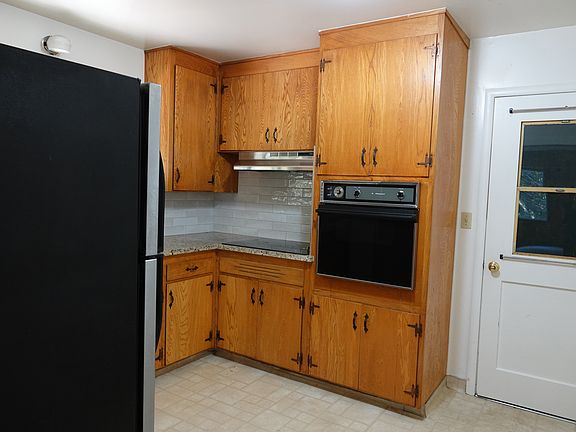 Solid wood cabinetry, granite-style countertops, and updated appliances create a warm, functional kitchen with classic character.