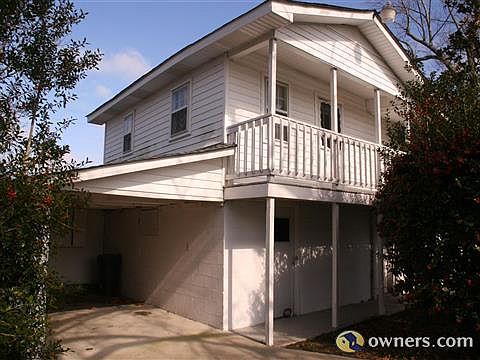 carport with storage rooms below and apartment above