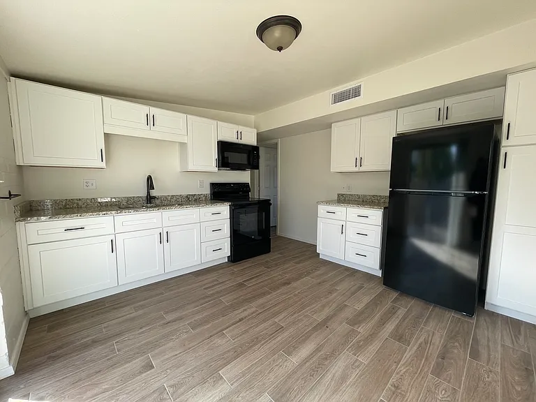 Kitchen w/ granite countertops, new cabinets, and appliances.