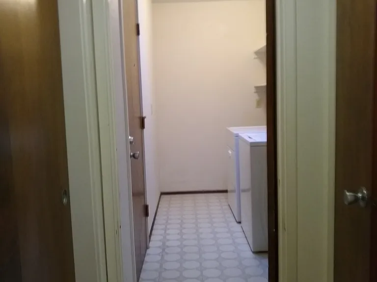 Laundry room is off a small hallway that connects to the long hallway.