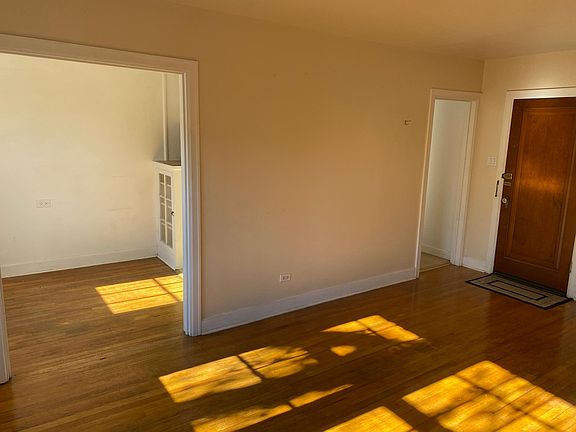Living room towards front door and dining and kitchen to left.