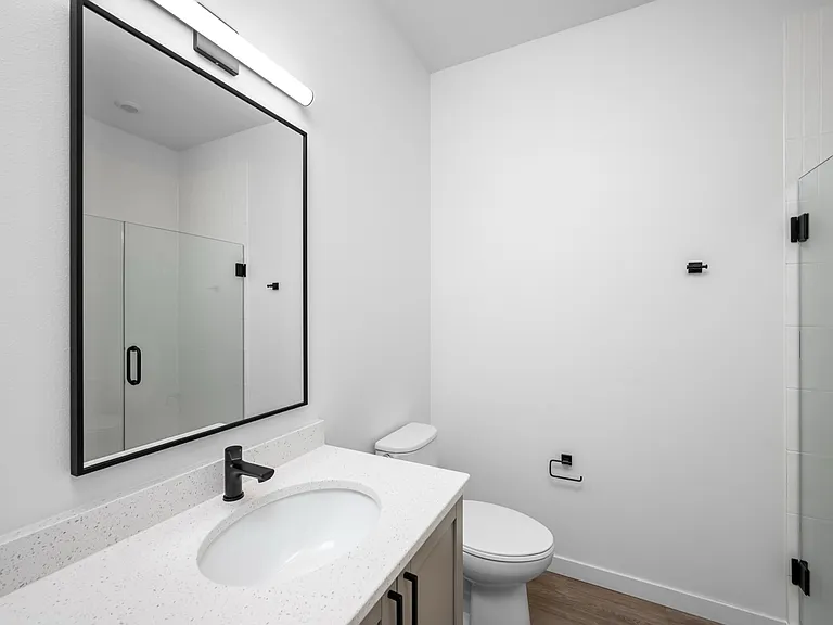 Modern bathroom with sleek vanity, spacious mirror, and elegant glass shower enclosure. Modern bathroom with sleek vanity, spacious mirror, and elegant glass shower enclosure.