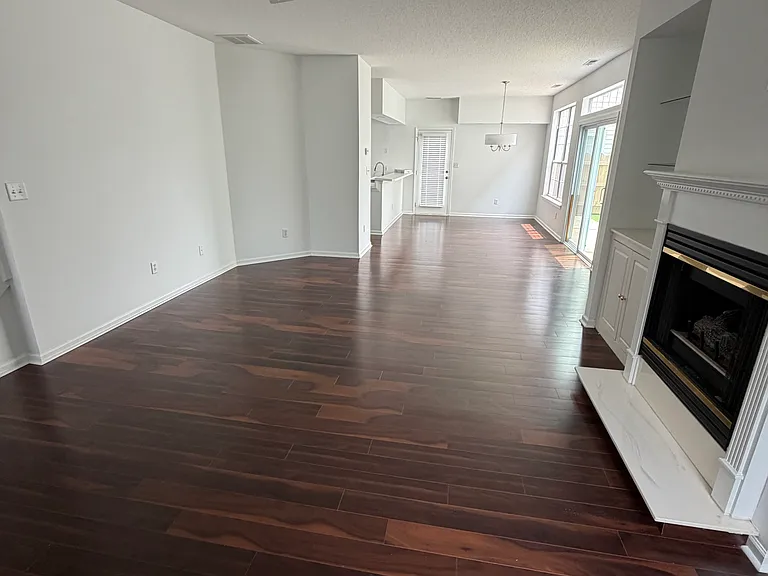 View of living room with fireplace and dining room to the back of the room