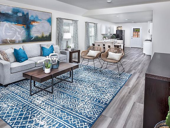 The spacious living room enjoys natural lighting and a layout that flows into the dining space and k