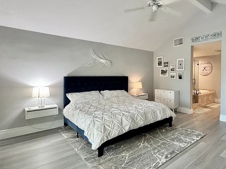 Upstairs primary bedroom with king bed and balcony overlooking the lake