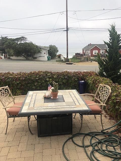 Outdoor fire pit on expansive patio looks out to ocean views and beach access