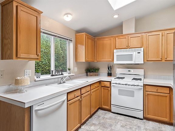 Kitchen is bright and has a skylight for plenty of natural light. Notice the double sinks and gas stove. 