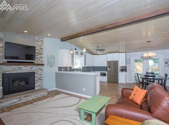 Bright, open living rm, kitchen & dining with vaulted, white-washed pine tongue & groove ceilings and wood laminate flooring is 