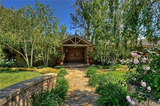 Front entrance, double solid wood doors, stone walkway, lush plantings