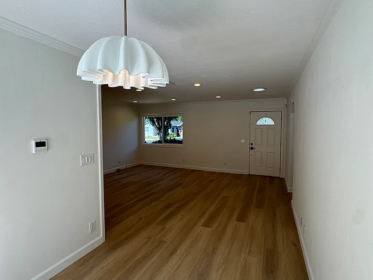 Dining area and living room. Dining room access to private backyard, mature garden, and spa.