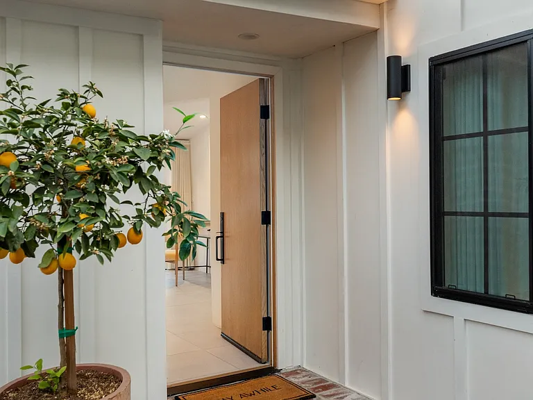 Step into charm, where a brick pathway and natural greenery welcome you home.
