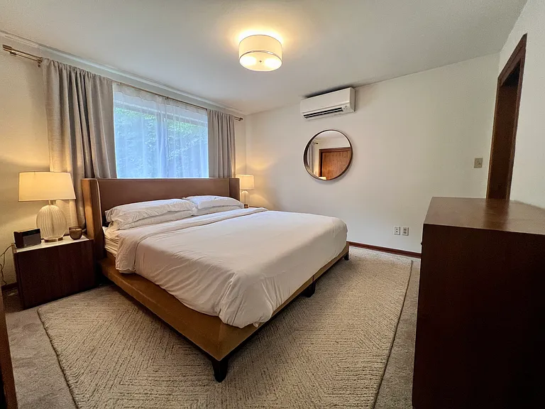 The main-floor primary bedroom features a Cal King mattress, A/C, a long closet, and a recently remodeled en-suite bathroom.