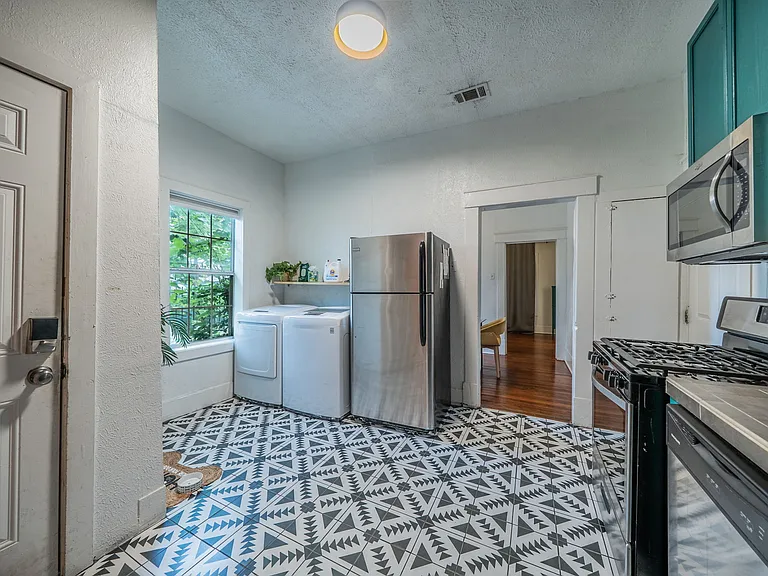Spacious open-concept kitchen and laundry area with natural light.